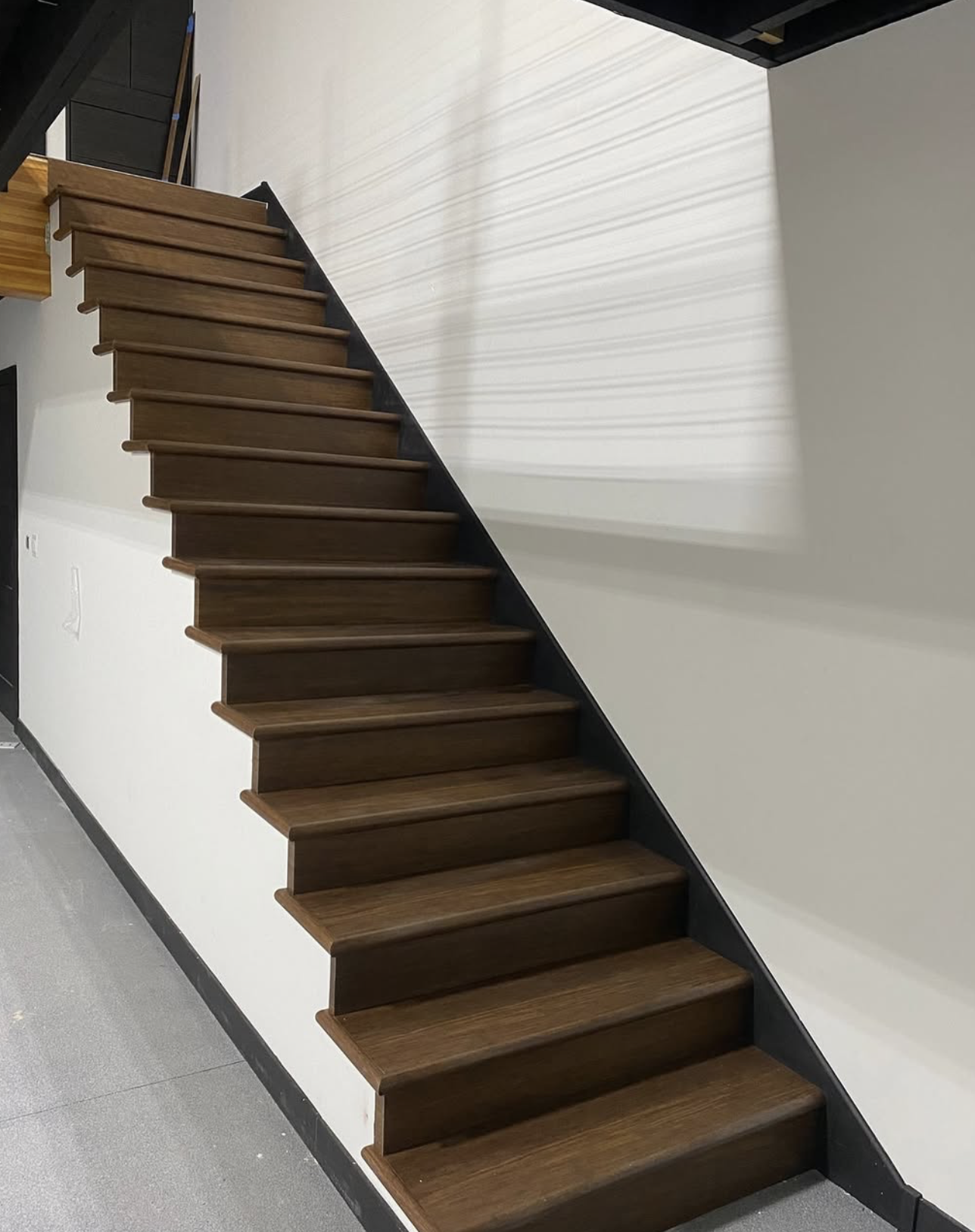 Custom stained stair treads and risers installed on a straight staircase